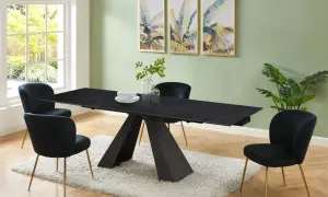 Elegante sala da pranzo con tavolo nero e sedie in velluto blu. Il colore pareti sala da pranzo è un verde tenue, che contrasta con le stampe tropicali.