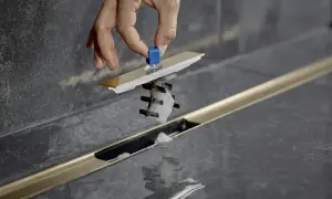 Mano rimuove filtro doccia intasato da capelli e schiuma. Pulire scarico doccia dai capelli è facile con questo strumento.