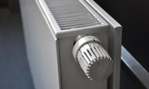 Dettaglio di elementi dei termosifoni: la manopola termostatica bianca con numeri e tacche per regolare la temperatura.