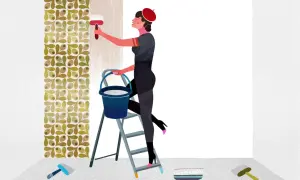 Donna su scala applica colla per carta da parati con un pennello. Sul pavimento, attrezzi per il fai-da-te.