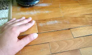 Mano sul parquet graffiato, un problema comune. Scopri come togliere i graffi dal parquet e ridare vita alla tua casa.