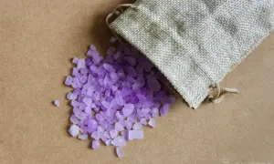 Sacchetti anti umidità fai da te con cristalli viola che fuoriescono da un sacchetto di juta.