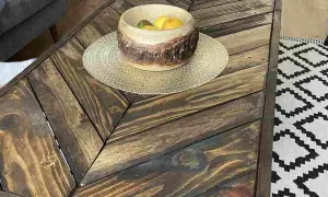 Tavolino con pallet fai da te, con ciotola di frutta e tappeto geometrico.