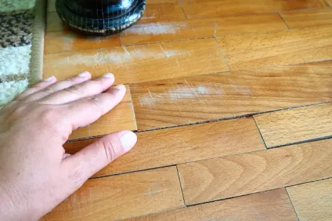 Mano sul parquet graffiato, un problema comune. Scopri come togliere i graffi dal parquet e ridare vita alla tua casa.