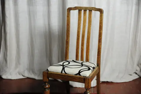 Sedia in legno con seduta imbottita e fantasia geometrica. Una guida su come tappezzare una sedia imbottita.
