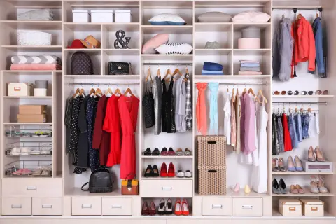 Armadio ordinato: come organizzare i vestiti con stile. Abiti, scarpe, borse e accessori ben disposti per un guardaroba funzionale.