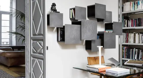 Moderna libreria a cubi grigi, un modo creativo per mettere i cubi al muro. Un Darth Vader LEGO veglia sui libri.