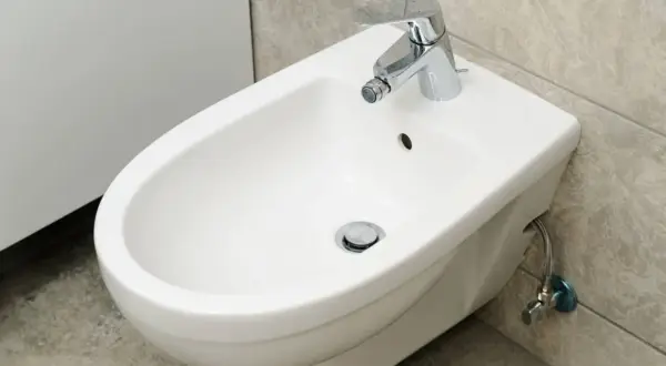 Bidet bianco con rubinetto cromato. Se hai problemi a sturare il bidet, questo è il primo passo per risolvere.