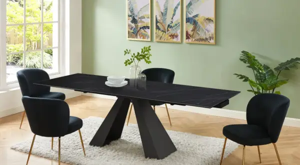 Elegante sala da pranzo con tavolo nero e sedie in velluto blu. Il colore pareti sala da pranzo è un verde tenue, che contrasta con le stampe tropicali.