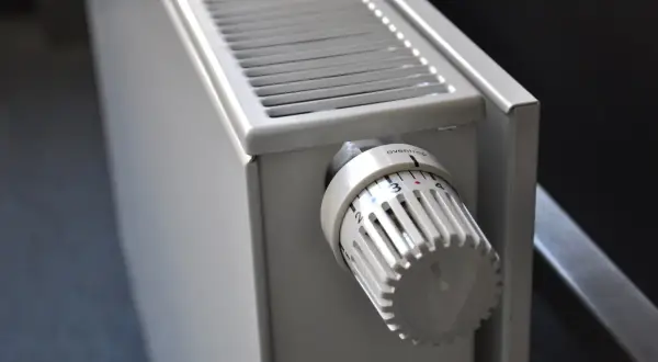 Dettaglio di elementi dei termosifoni: la manopola termostatica bianca con numeri e tacche per regolare la temperatura.