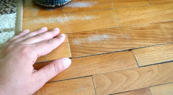 Mano sul parquet graffiato, un problema comune. Scopri come togliere i graffi dal parquet e ridare vita alla tua casa.