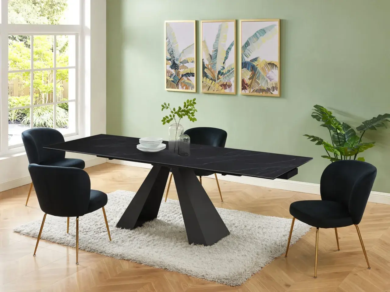 Elegante sala da pranzo con tavolo nero e sedie in velluto blu. Il colore pareti sala da pranzo è un verde tenue, che contrasta con le stampe tropicali.