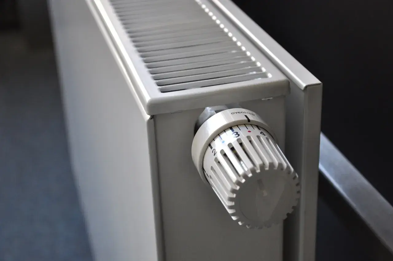 Dettaglio di elementi dei termosifoni: la manopola termostatica bianca con numeri e tacche per regolare la temperatura.