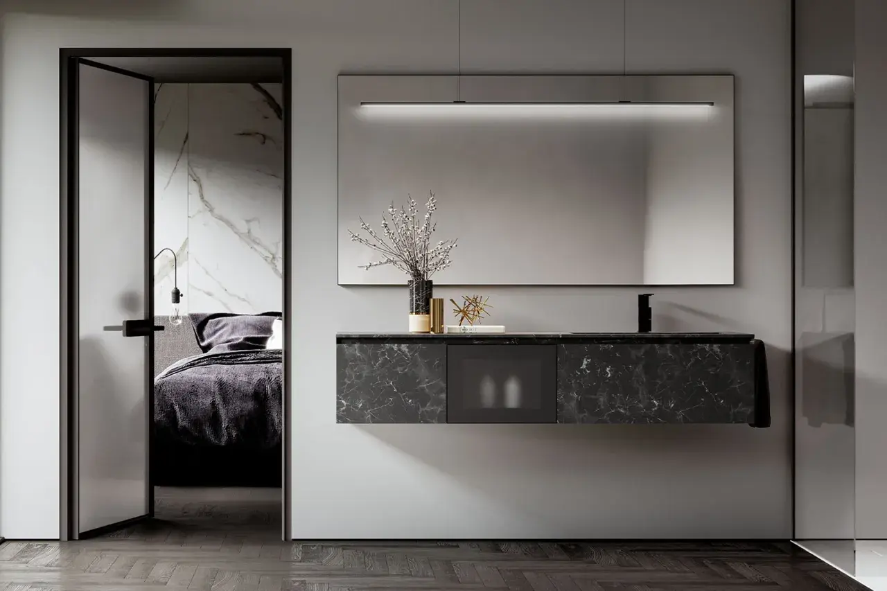 Arredamento moderno per un bagno cieco: mobile sospeso in marmo nero, specchio illuminato e porta scorrevole che rivela una camera da letto.