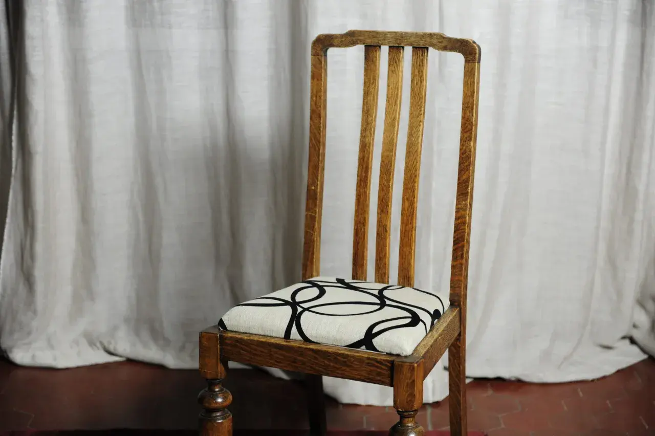 Sedia in legno con seduta imbottita e fantasia geometrica. Una guida su come tappezzare una sedia imbottita.