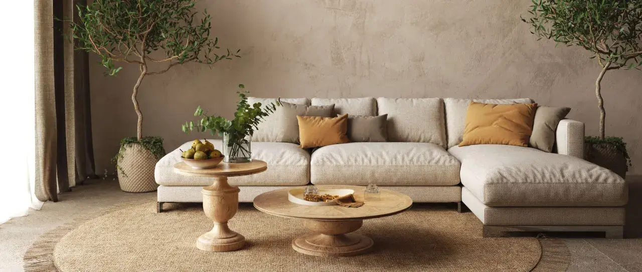 Un divano componibile beige, tavolini in legno, piante e cuscini color ocra creano salotti caldi e accoglienti, perfetti per rilassarsi.