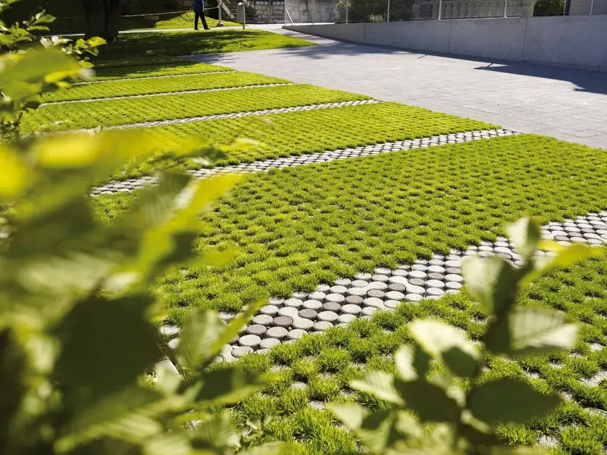 Un parcheggio con grigliati erbosi, una soluzione di posa a secco su terra che integra verde e pavimentazione.