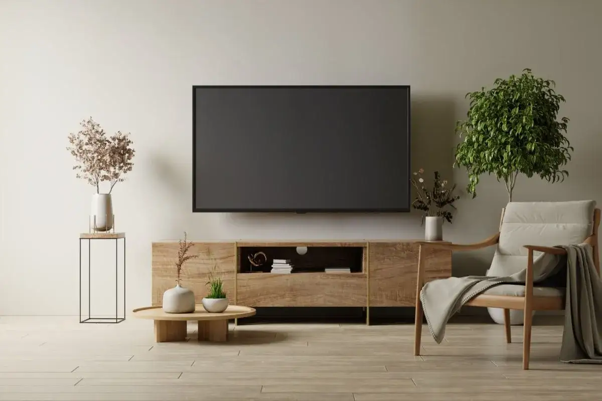 Mobile TV in legno con un'altezza perfetta da terra, con poltrona e piante.