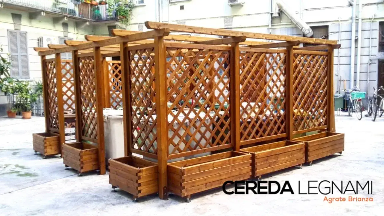 Strutture in legno fai da te per nascondere bidoni e creare un angolo verde. Fioriere in legno completano l'arredo.