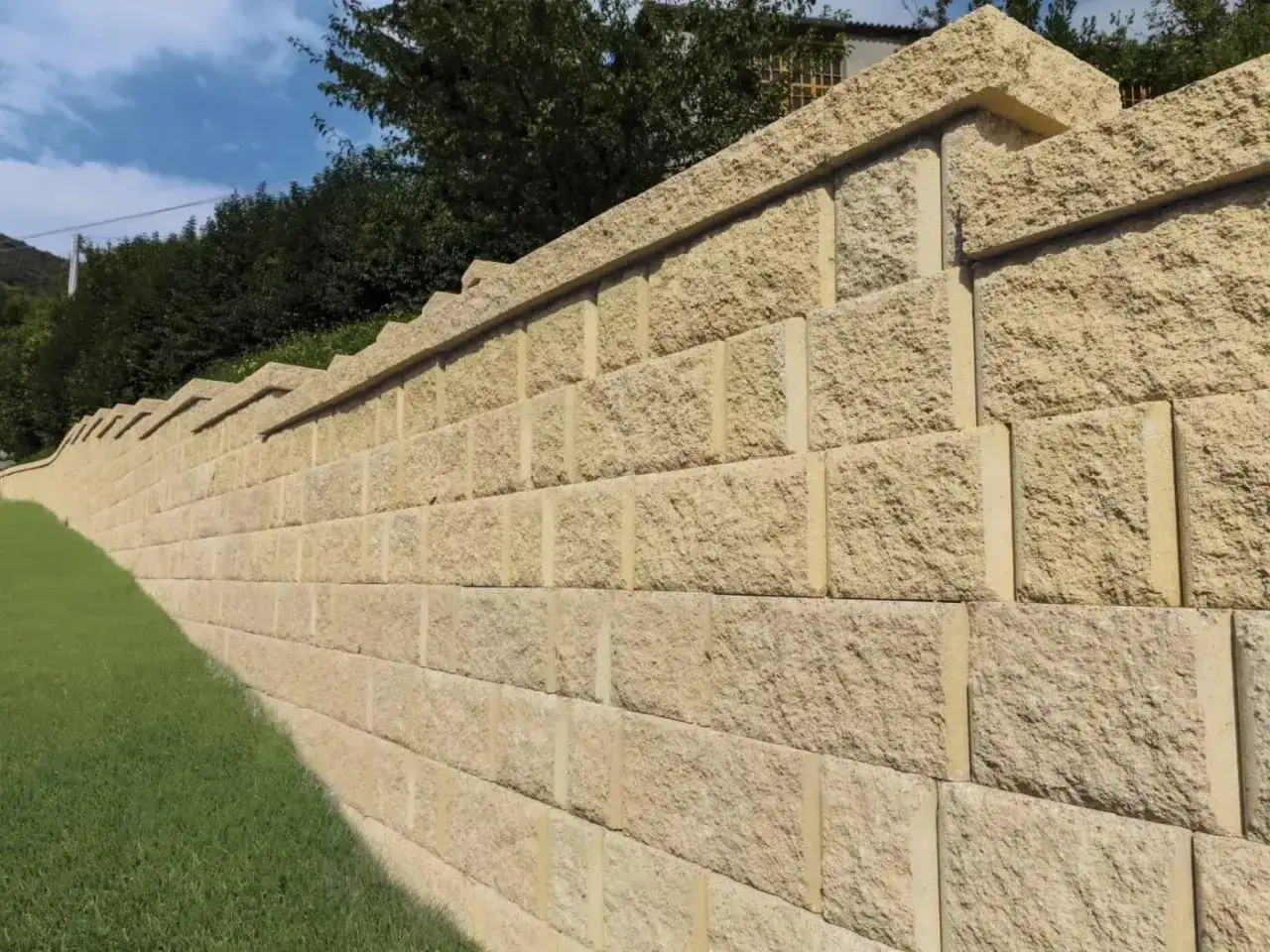 Muro a secco per contenimento terra, con blocchi in pietra chiara che seguono l'andamento del terreno.