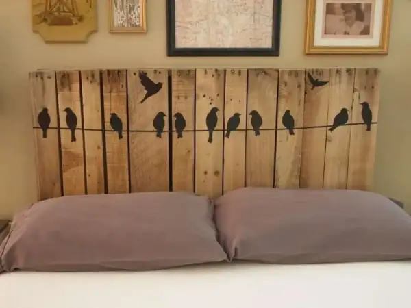 Testiera letto fai da te in legno di pallet con sagome di uccelli su un filo. Un progetto creativo per la tua camera da letto.