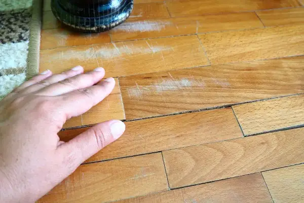 Mano sul parquet graffiato, un problema comune. Scopri come togliere i graffi dal parquet e ridare vita alla tua casa.