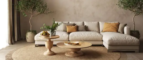 Un divano componibile beige, tavolini in legno, piante e cuscini color ocra creano salotti caldi e accoglienti, perfetti per rilassarsi.