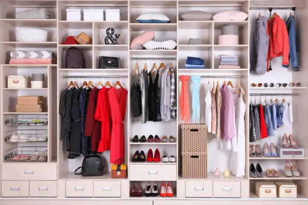 Armadio ordinato: come organizzare i vestiti con stile. Abiti, scarpe, borse e accessori ben disposti per un guardaroba funzionale.