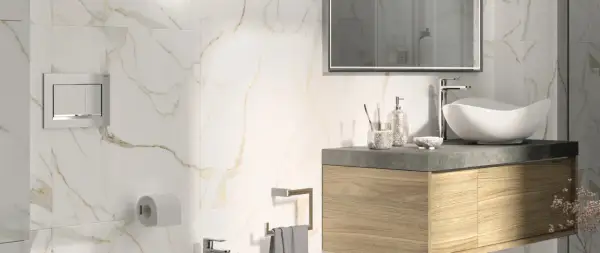 Bagno moderno con piastrelle effetto marmo e oro. Lavabo bianco, mobile in legno, specchio e accessori. Guida su come posare le piastrelle del bagno.